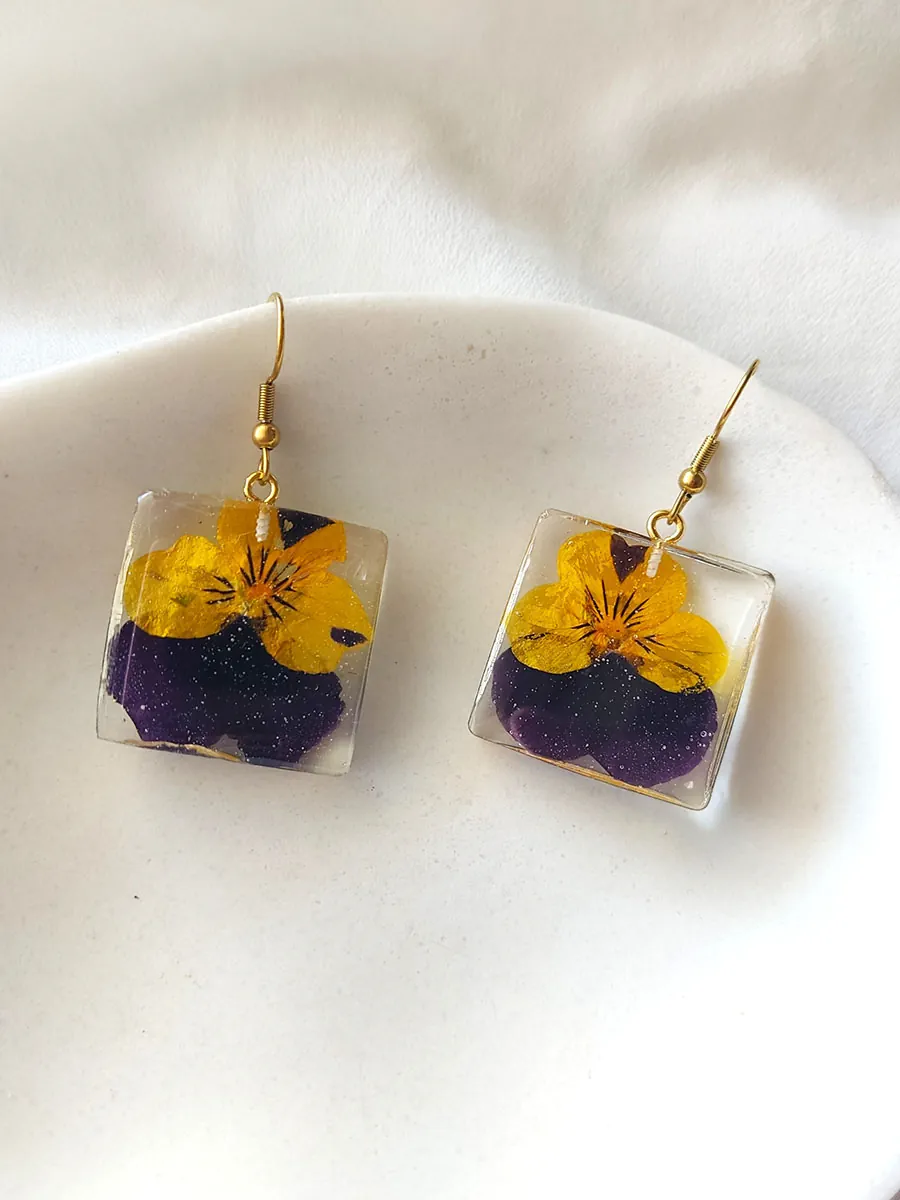 BL_EARRINGS-0013 Σκουλαρίκια ατσάλινα κρεμαστά τετράγωνα με αληθινά άνθη δίχρωμου πανσέ | Blossom Jewelry Collection